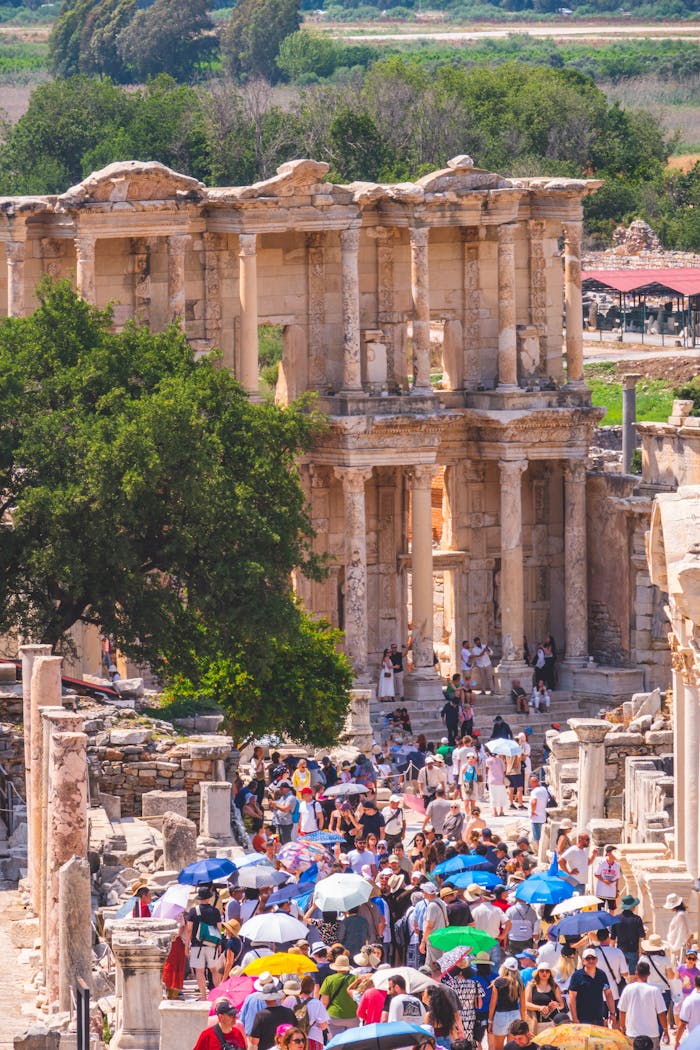 The Architecture of Progressive Tourism: How Private Hospitality Can Drive Regional Communitarian Ecosystems Tourists exploring the historic ruins of the Library of Celsus in Ephesus, Türkiye.
